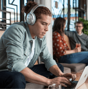a man wearing headphones and using a laptop