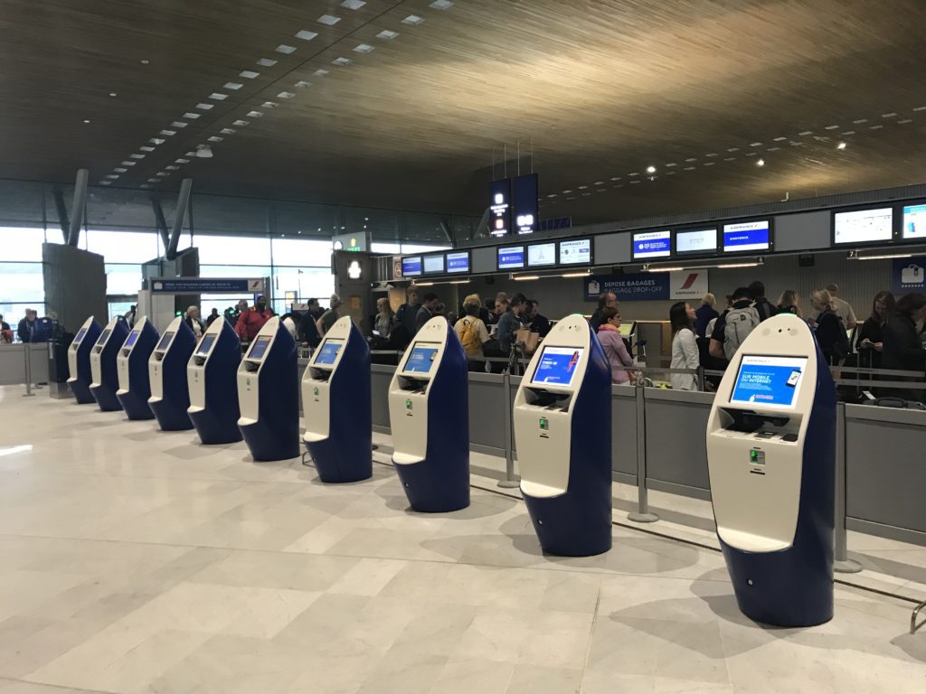 a row of blue and white kiosks in a terminal