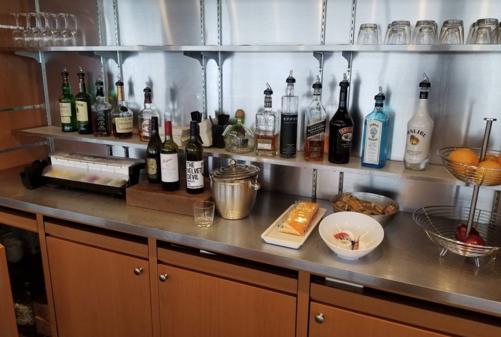 a bar with bottles of alcohol and food on a counter