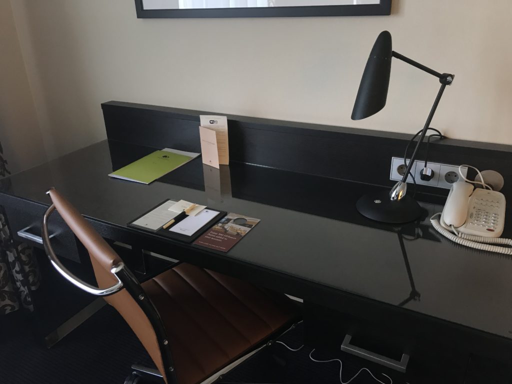a desk with a lamp and a picture on the wall