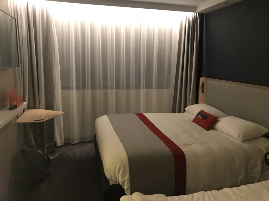a bed with a table and a desk in a hotel room