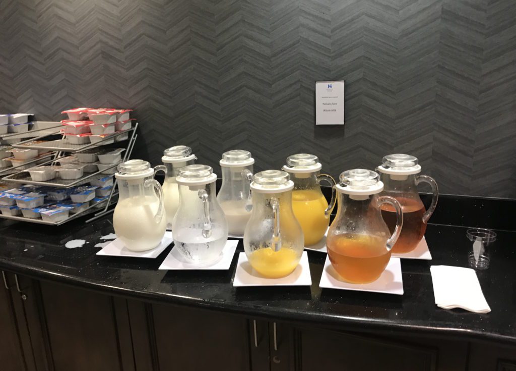 a group of pitchers with different types of liquid on plates