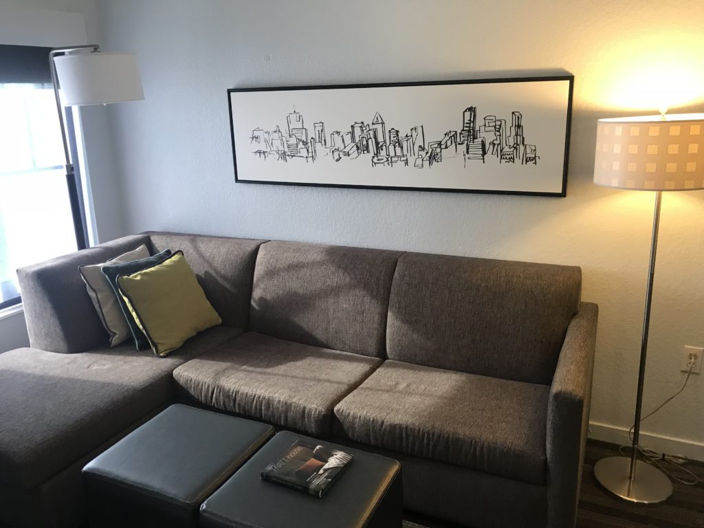 a couch with pillows and a painting on the wall