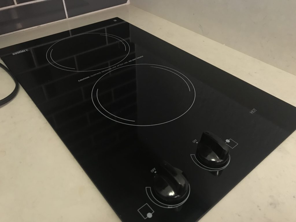 a black stove top with knobs