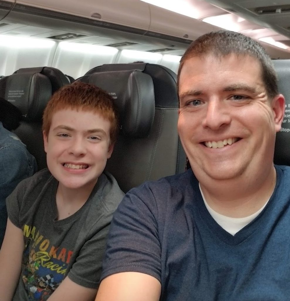 a man and boy sitting in a plane