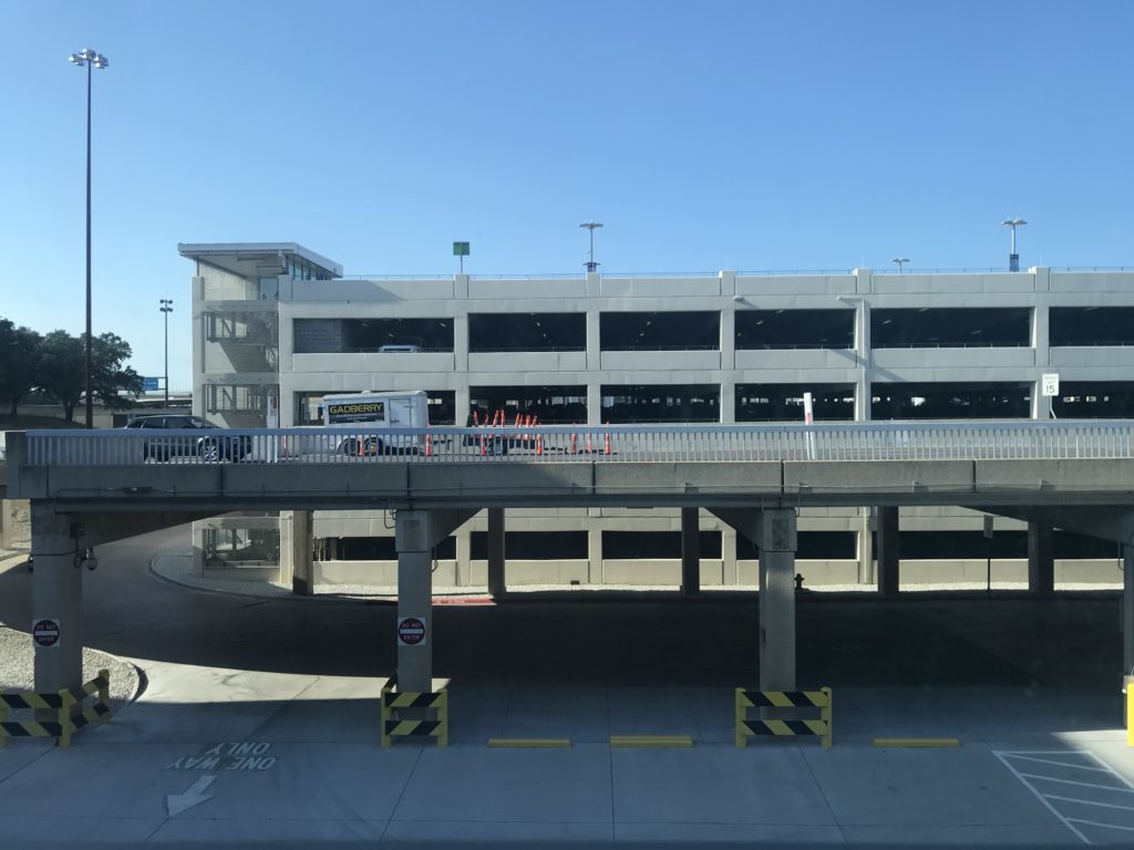 a parking garage with a bridge and a parking lot