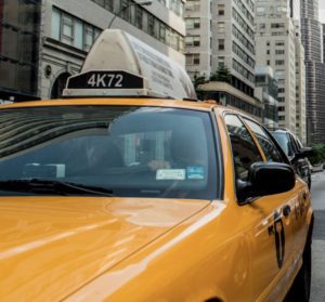 a yellow taxi cab in a city