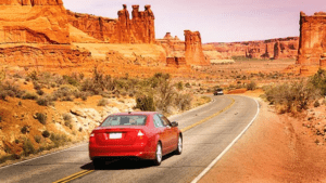 a red car driving on a road
