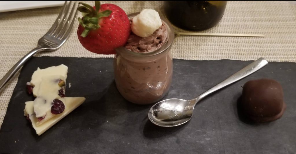 a glass jar with a strawberry and a spoon