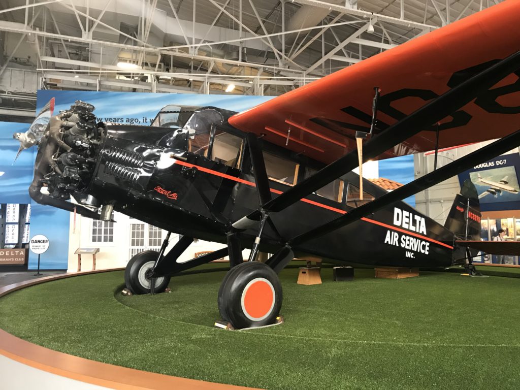 a black and orange airplane on a green field
