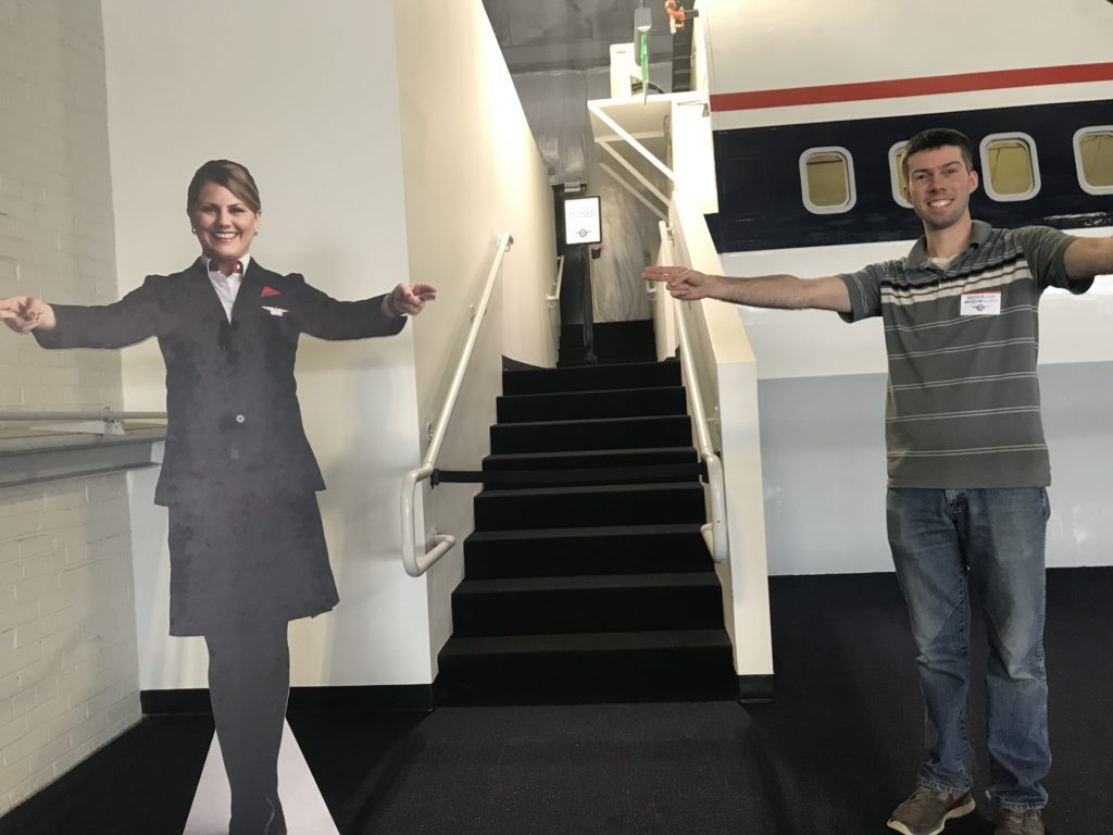a man standing next to a cardboard cutout of a woman