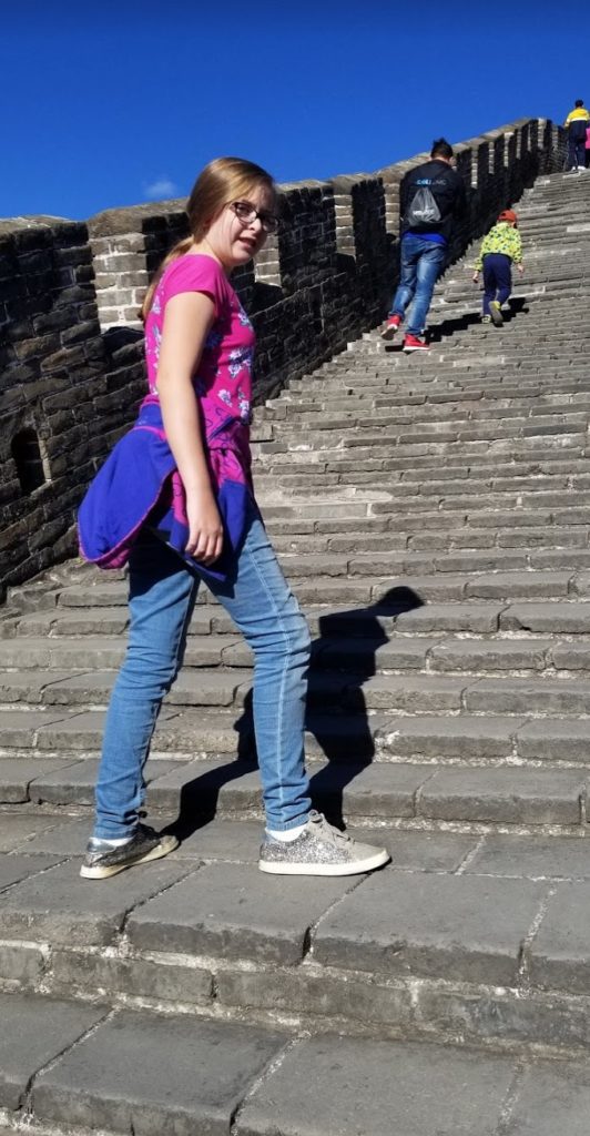 a girl walking up a stone staircase