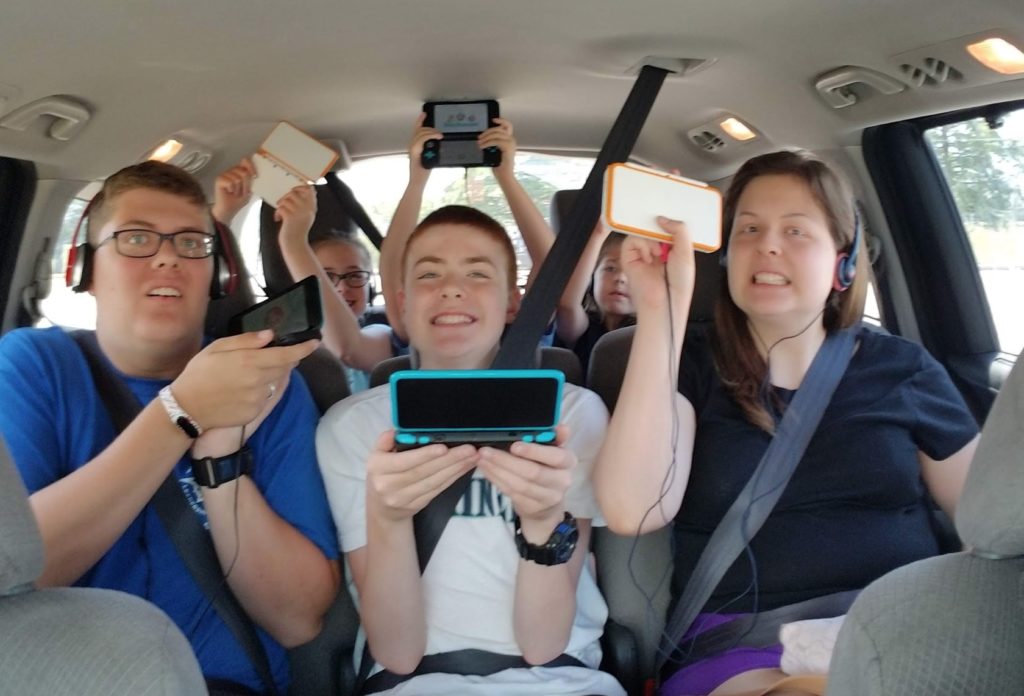 a group of people in a car holding devices