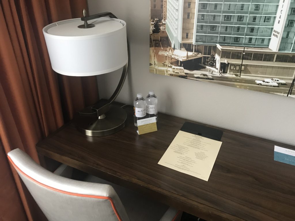 a desk with a lamp and a paper on it