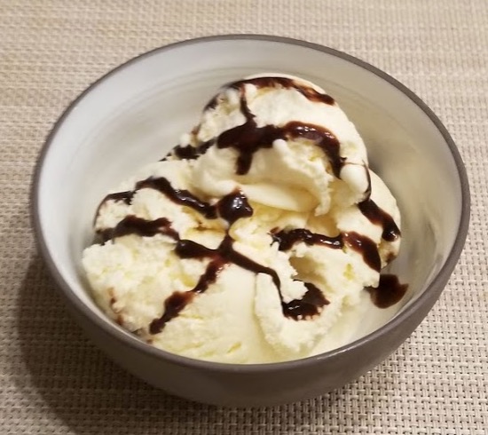 a bowl of ice cream with chocolate syrup