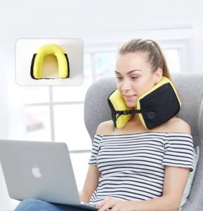 a woman sitting in a chair with a neck pillow