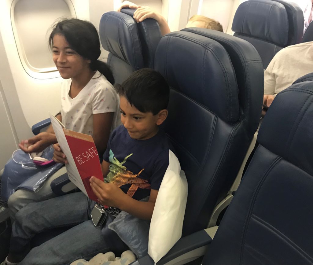 a boy and girl sitting on an airplane