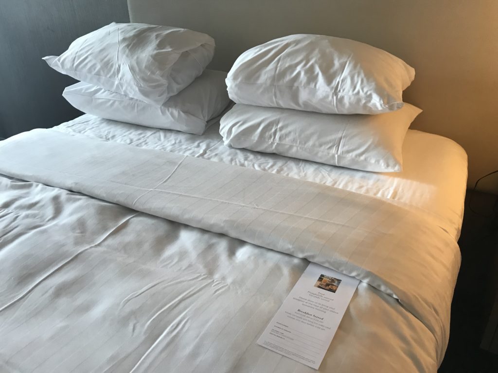 a bed with white sheets and a white sheet