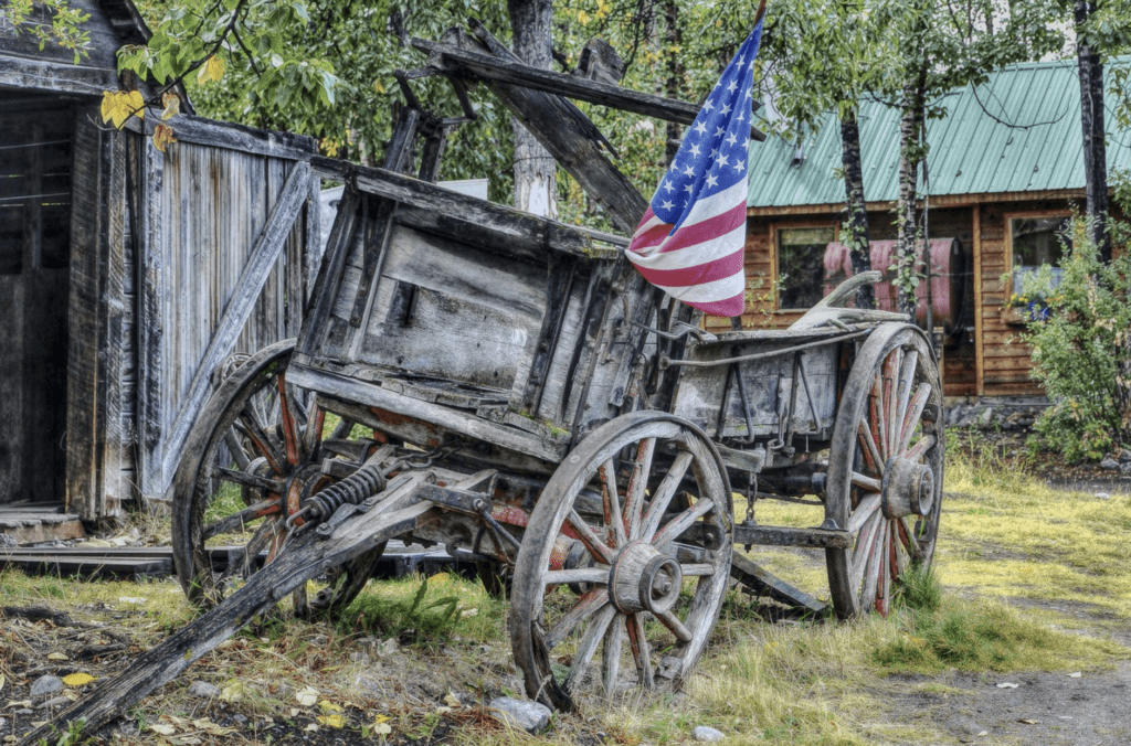 an old wooden carriage with a flag on it