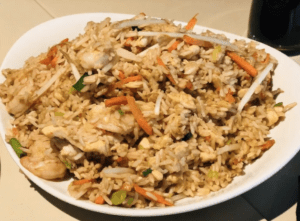 a plate of rice with meat and vegetables