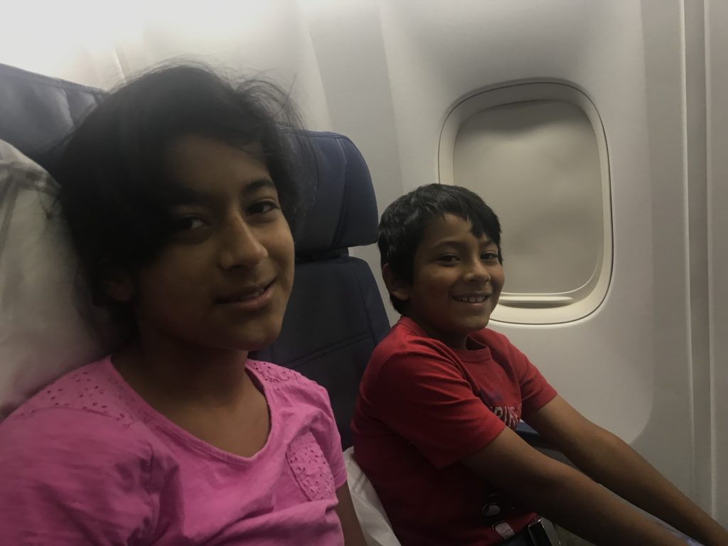 a couple of kids sitting in an airplane