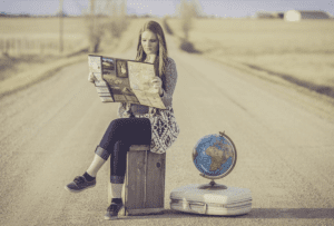 a woman sitting on a box looking at a map