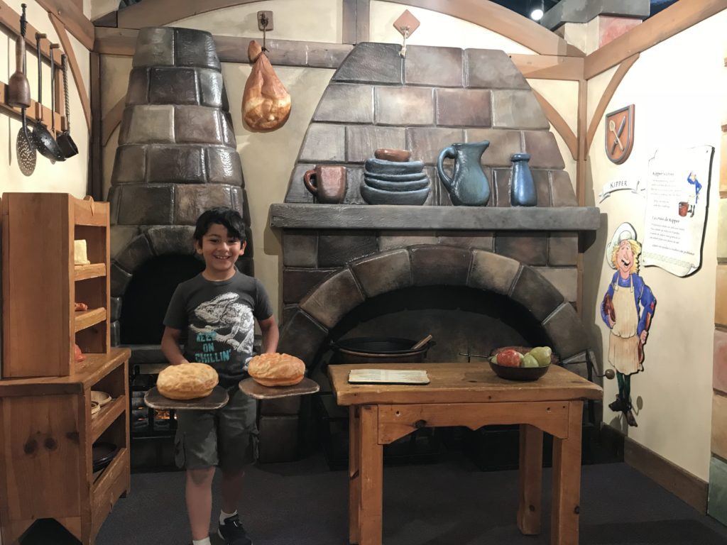 a boy holding two plates of bread
