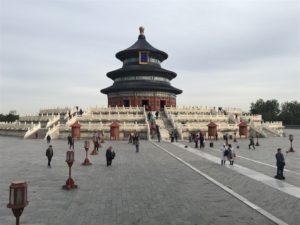 a large circular building with stairs leading to it with Temple of Heaven in the background