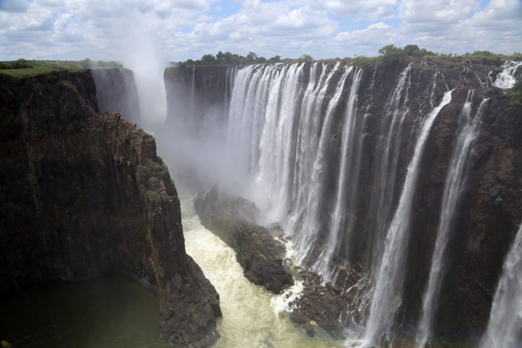 a large waterfall with a body of water coming out of it with Victoria Falls in the background