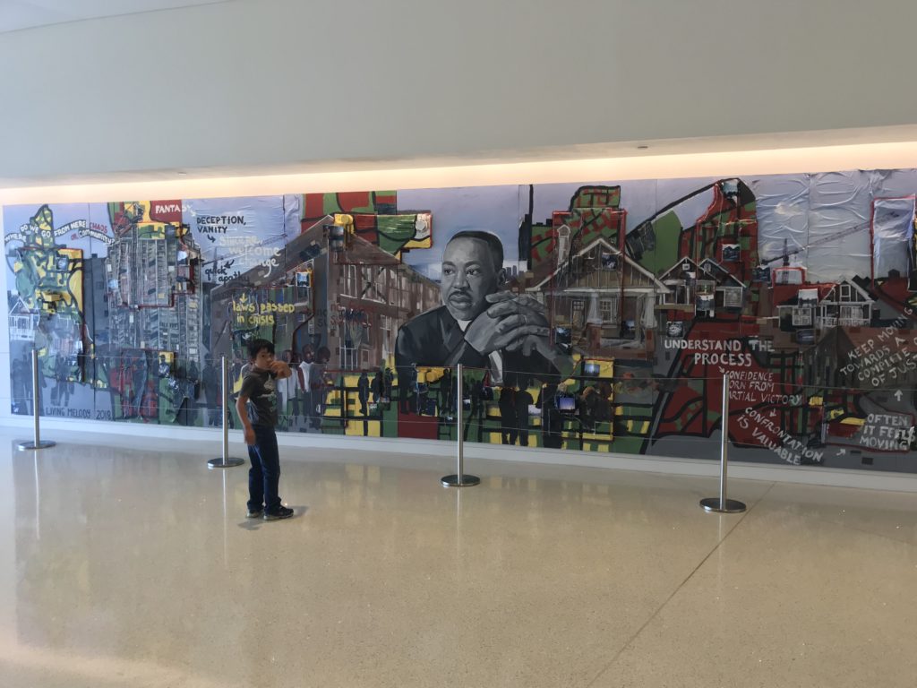 a boy standing in front of a mural