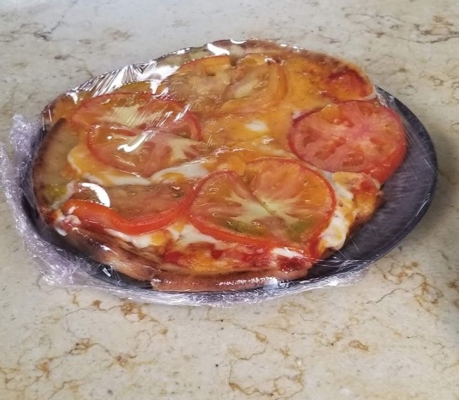 a pizza with tomatoes and cheese on a plate