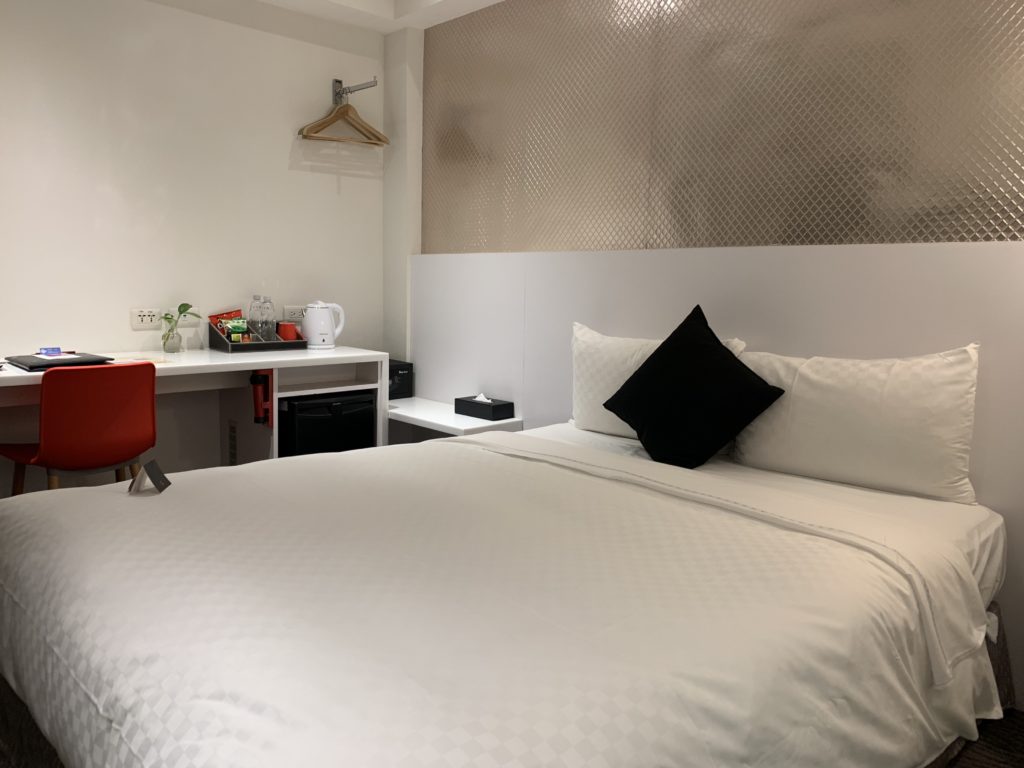a bed with a white sheet and black pillows