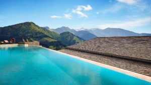 a pool on top of a roof overlooking mountains
