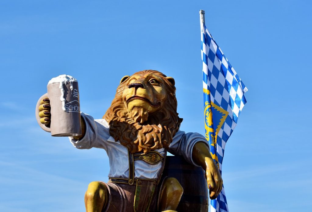 a statue of a lion holding a beer mug and a flag
