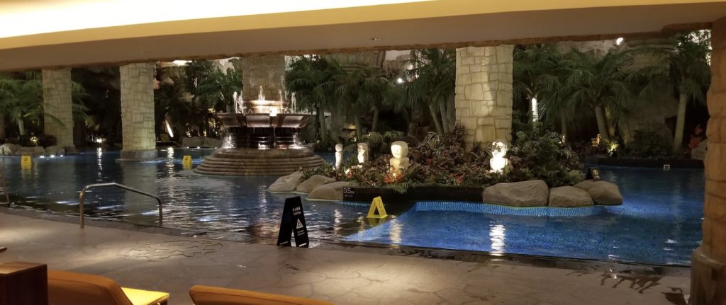 a pool with a fountain and statues