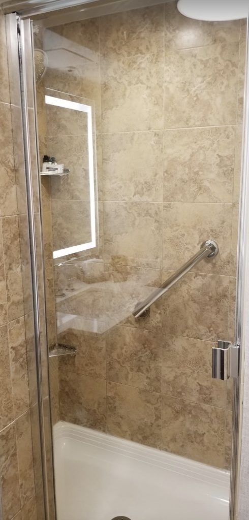 a glass shower with a light on the glass door
