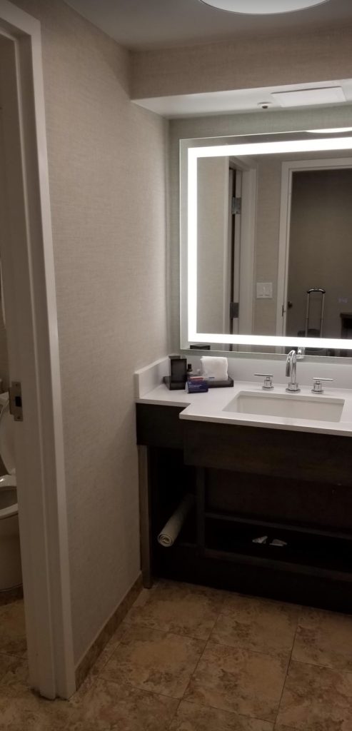 a bathroom sink with a lighted mirror