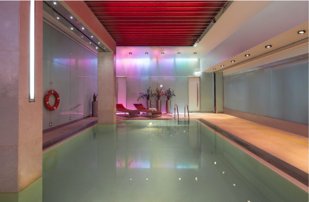 a indoor pool with a red and pink ceiling