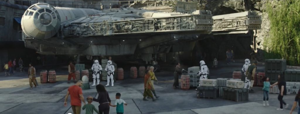 a group of people walking near a large spaceship