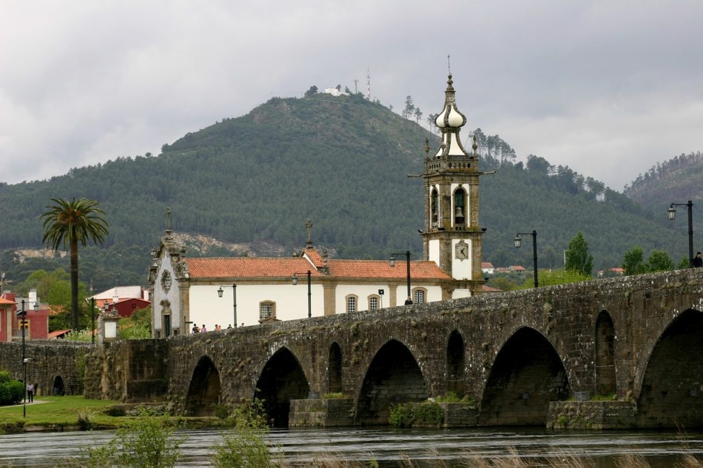 a stone bridge with a building and a tower