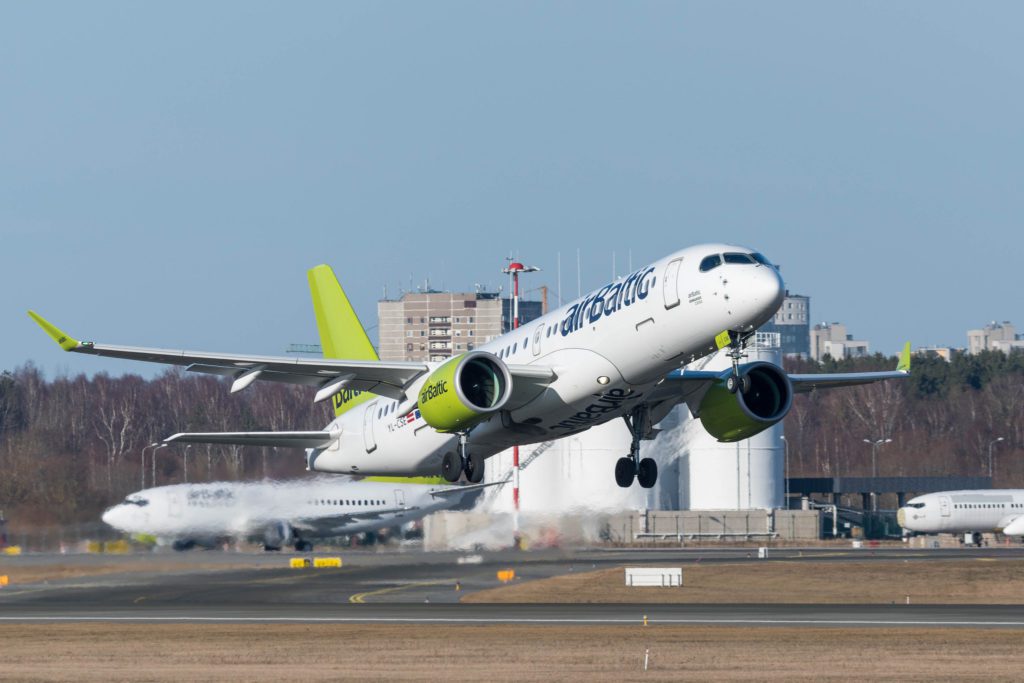 a white and green airplane taking off from a runway