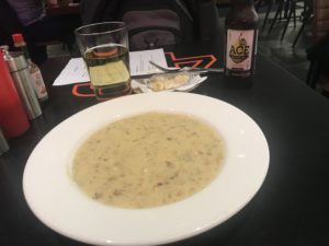 a plate of soup and beer on a table