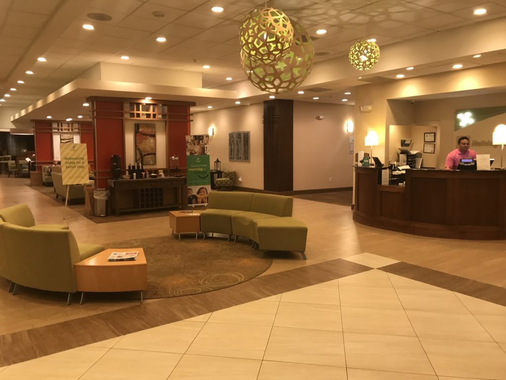 a lobby with a reception desk and green couches