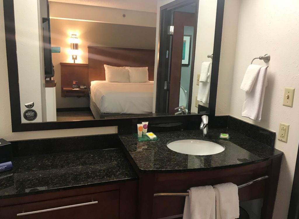 a bathroom with a mirror and a bed