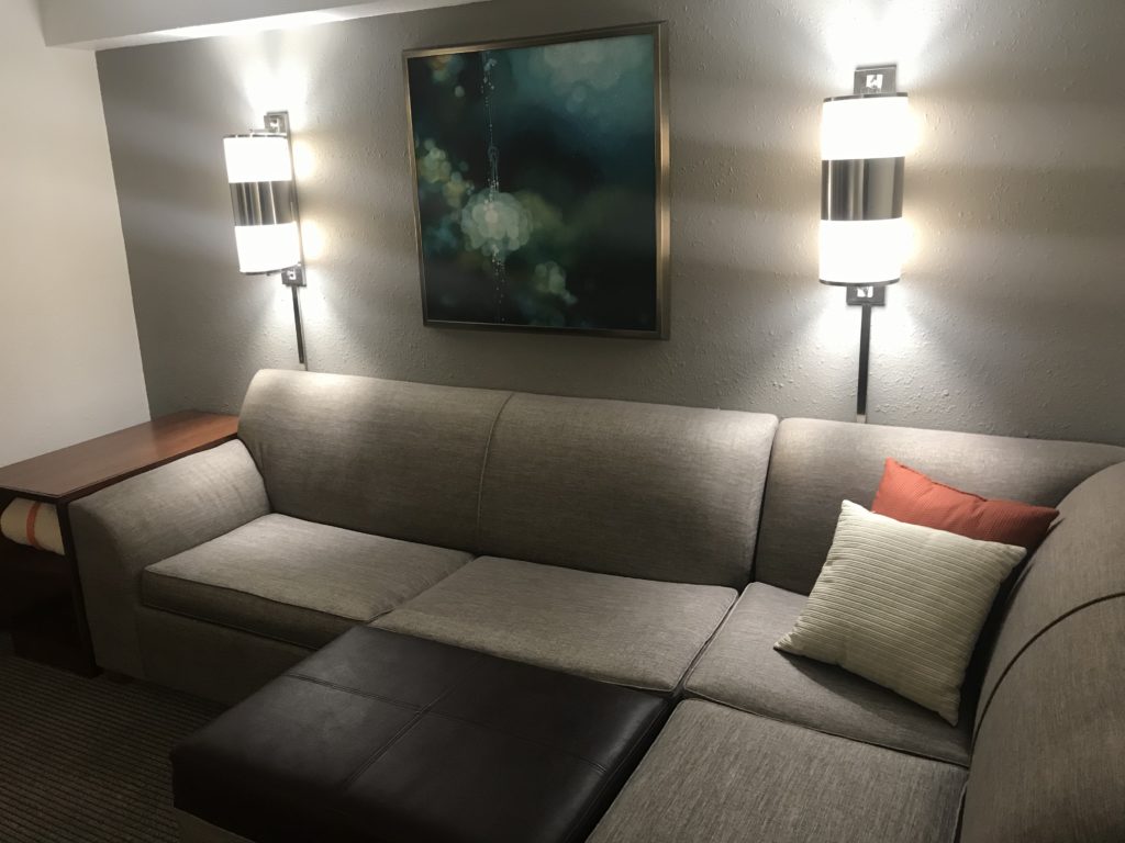 a couch with pillows and a painting on the wall
