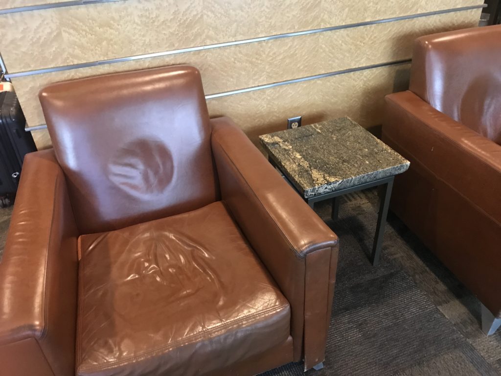 a brown leather chairs next to a small table