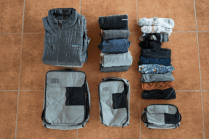 a group of folded clothes and a backpack