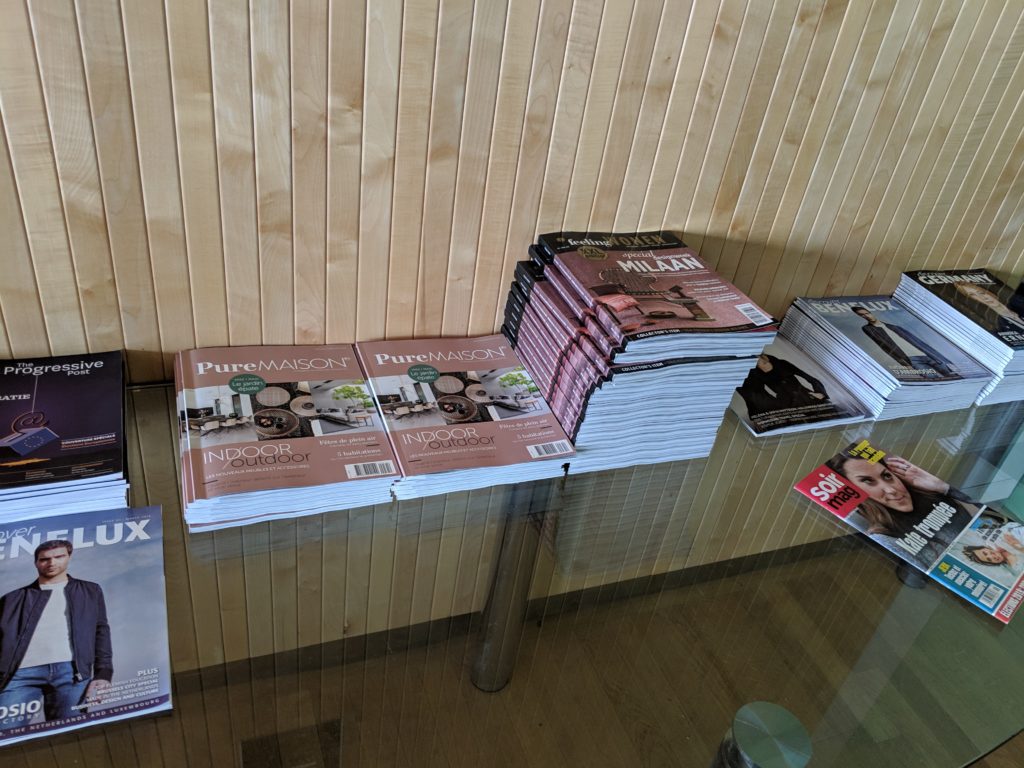 a stack of magazines on a glass table