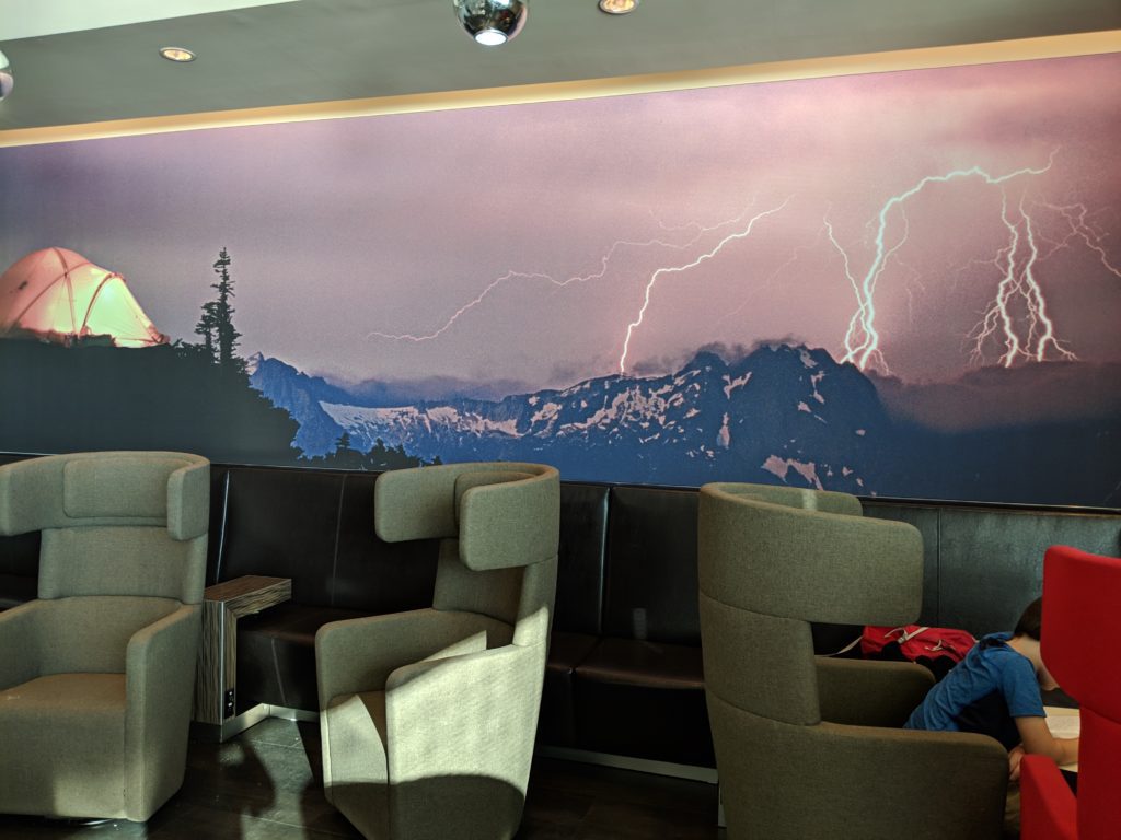a room with a wall mural of mountains and lightning