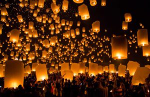 a group of people holding lanterns in the air